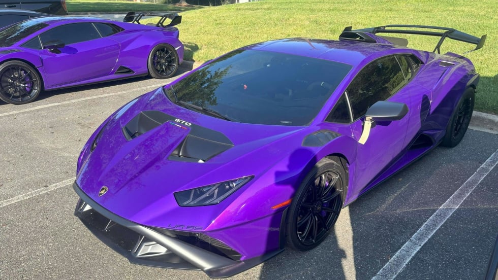 Vibrant purple Lamborghini sports car with aerodynamic design parked on asphalt