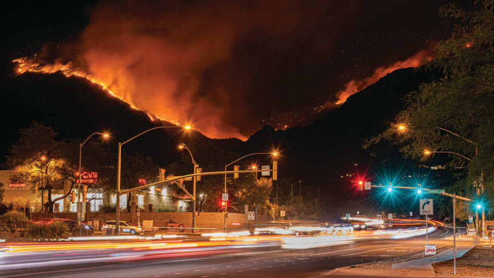An empty street with a background of a wild fire mountain