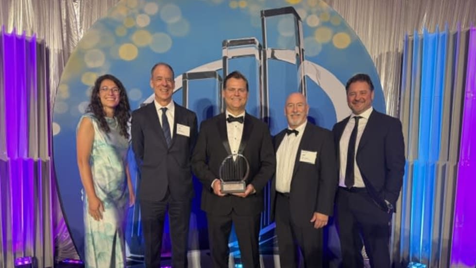 Tod Eskra stands on an award stage to accept recognition