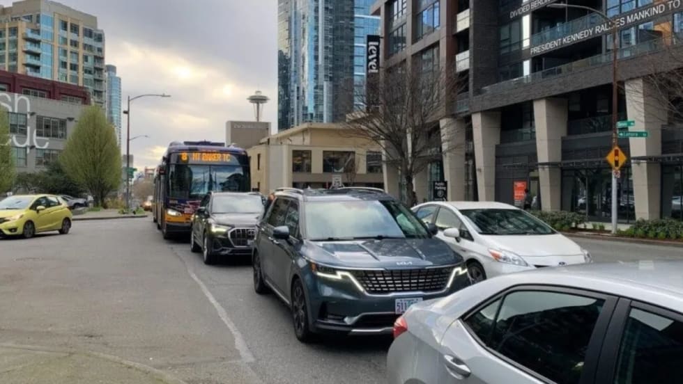 A Route 8 bus travels on Denny Way in congested traffic.