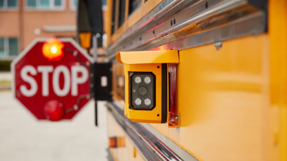 A Gatekeeper Systems camera mounted on the side of a school bus.