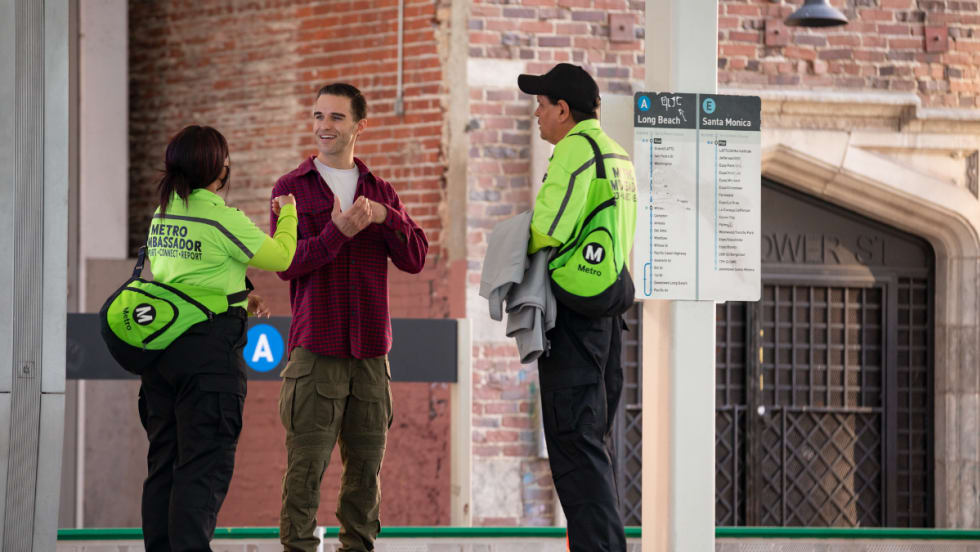 A man speaks with two Los Angeles Metro Ambassadors.
