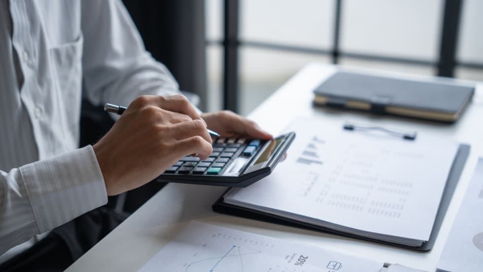 man sitting at desk using a calculator