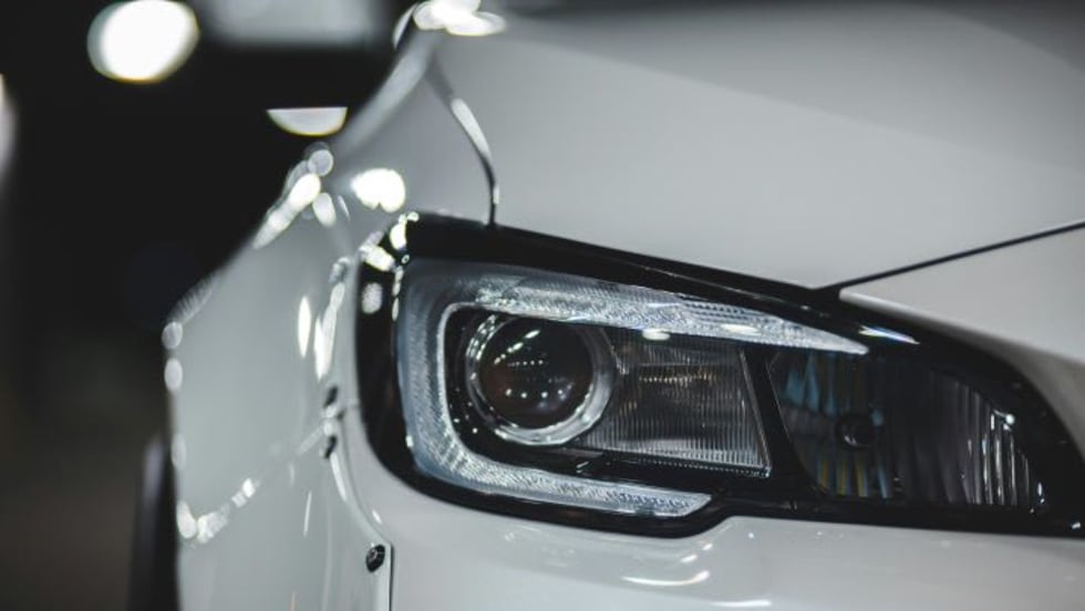 Closeup of white car's headlight, front end