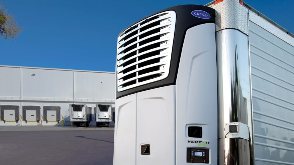 Carrier Transicold electric transport refrigeration unit on stationary trailer with loading docks in the background