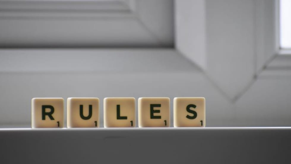 Photo of scrabble letters spelling 'RULE' sitting on a surface