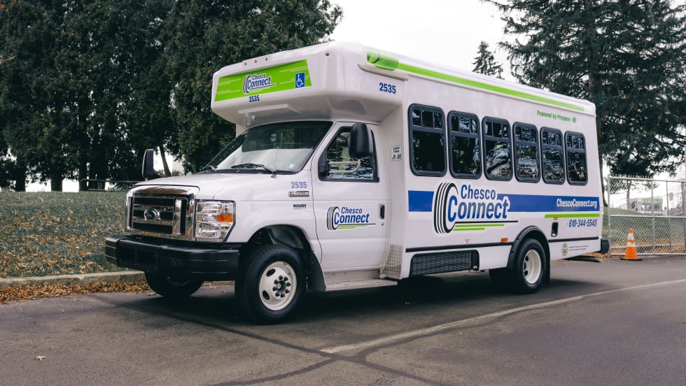 A white Chesco Connect paratransit bus parked outside.