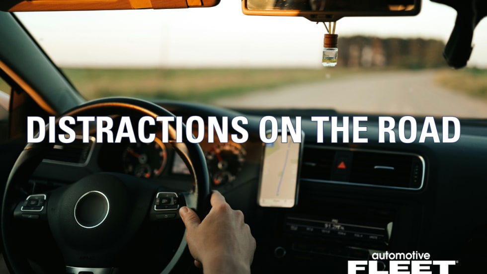 A person with hands on the steering wheel driving