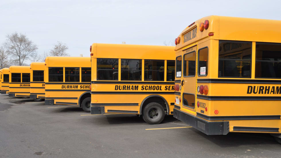 Lineup of the back end of Durham School Service school buses.