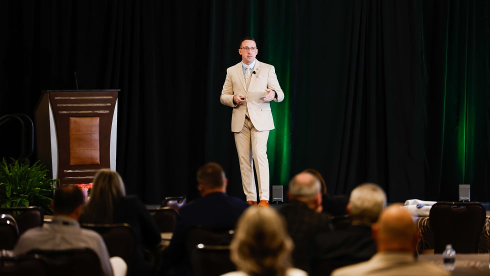 Dustin Gingerich standing on stage giving a presentation