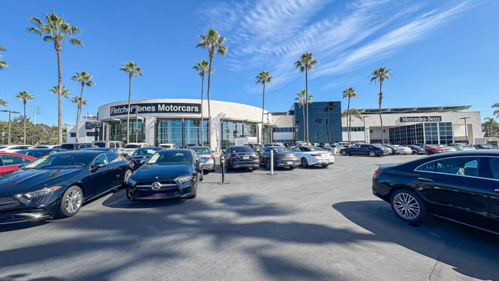 outside shot of Fletcher Jones Motorcars, white building with various cars out front