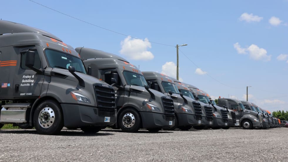Line of gray semi trucks with Fraley & Schilling logo