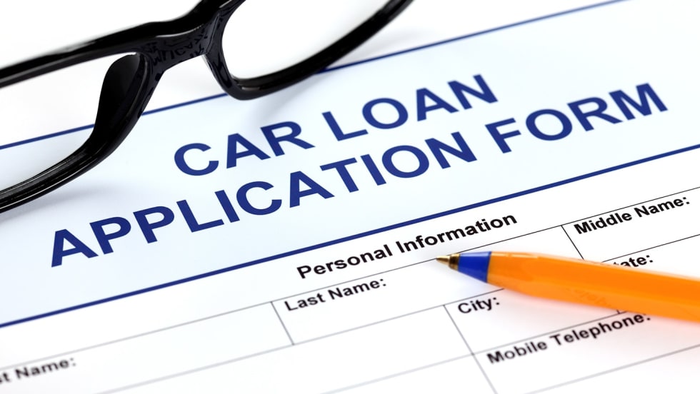 Image of a car loan application form with eyeglasses and a pencil sitting on top