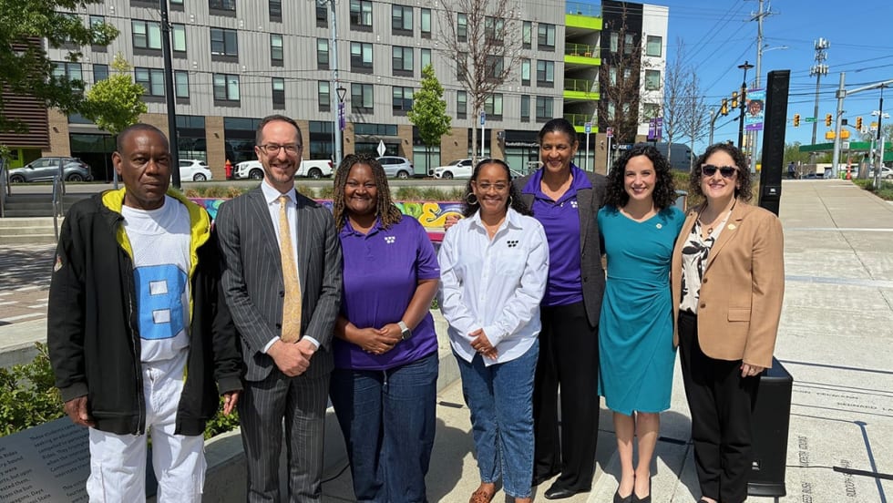 A group of people pose for a picture outside.