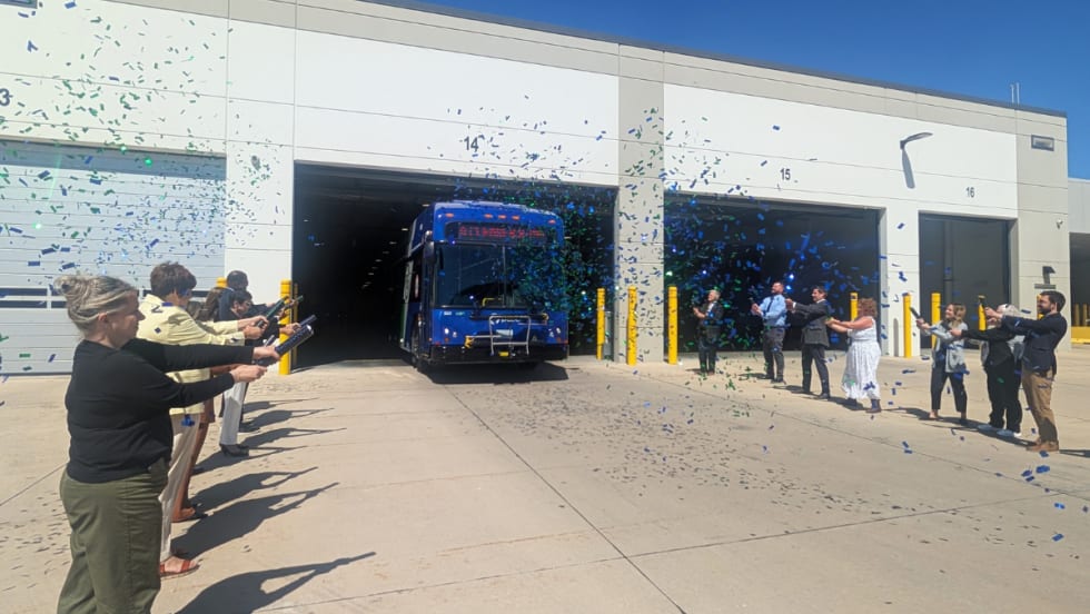 A group of people with confetti cannons and a Pace transit bus.