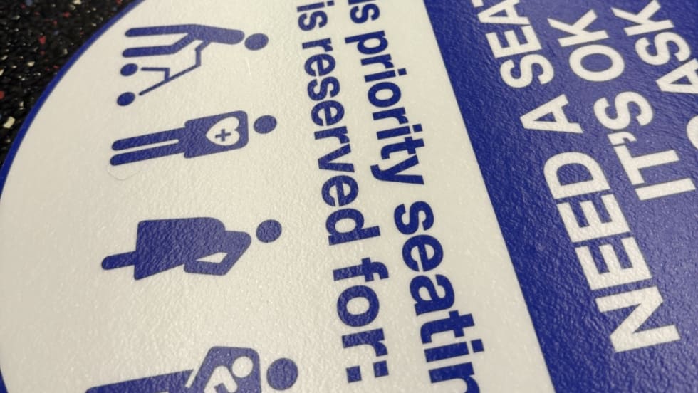 An up close image of WMATA priority seating sticker reminders.