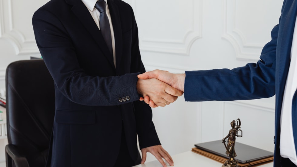 two men in suits shaking hands