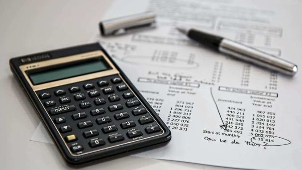 Photo of document next to calculator and inkpen