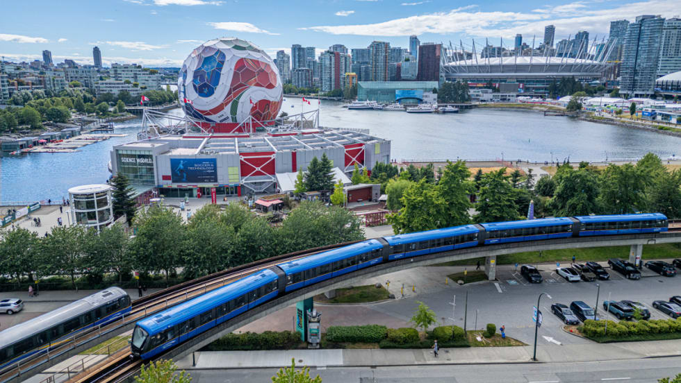 A TransLink train goes by a large FIFA World Cup soccer ball structure.