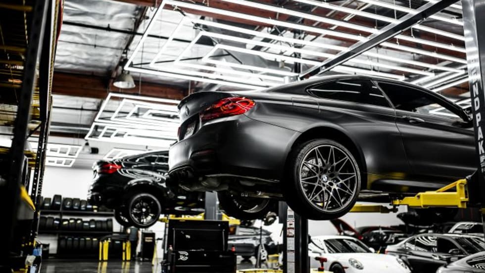 Photo of several cars on lifts in a service center