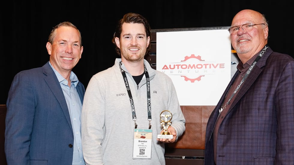 Photo of two men representing winning company, along with the award presenter
