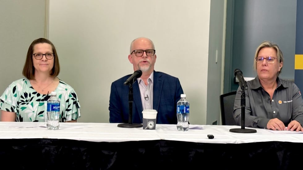Three people at a table for a panel discussion