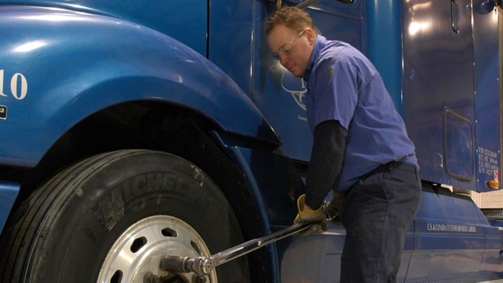 Truck mechanic tightening wheel nuts