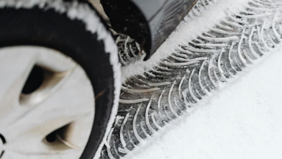 Photo of car tire and the tread mark it left in snow