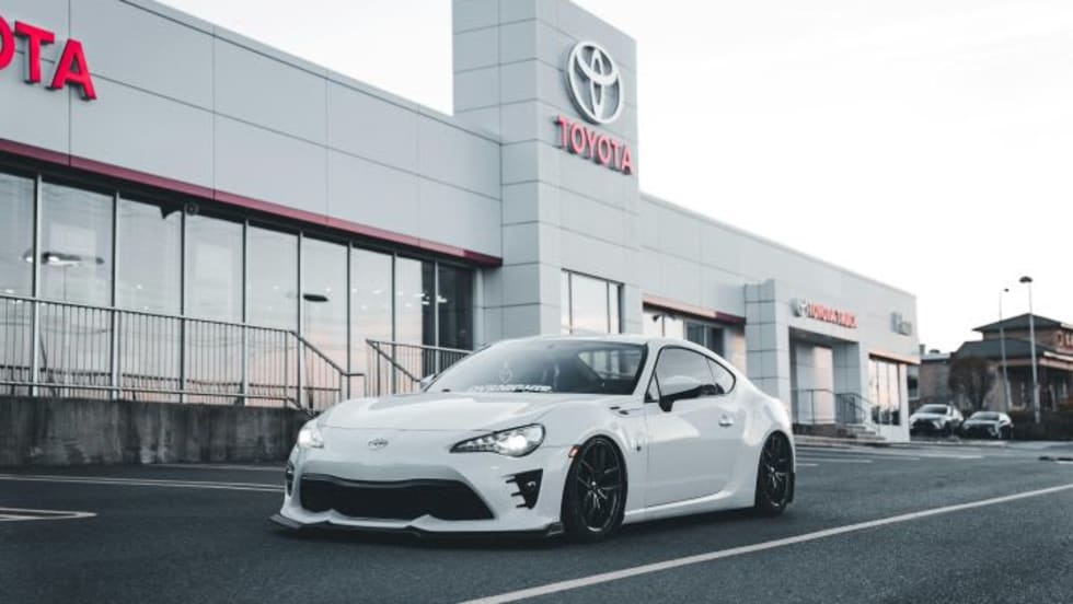 Photo of white Toyota car in front of dealership