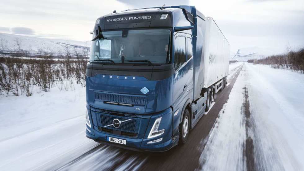 Blue Volvo European cabover truck on snowy road