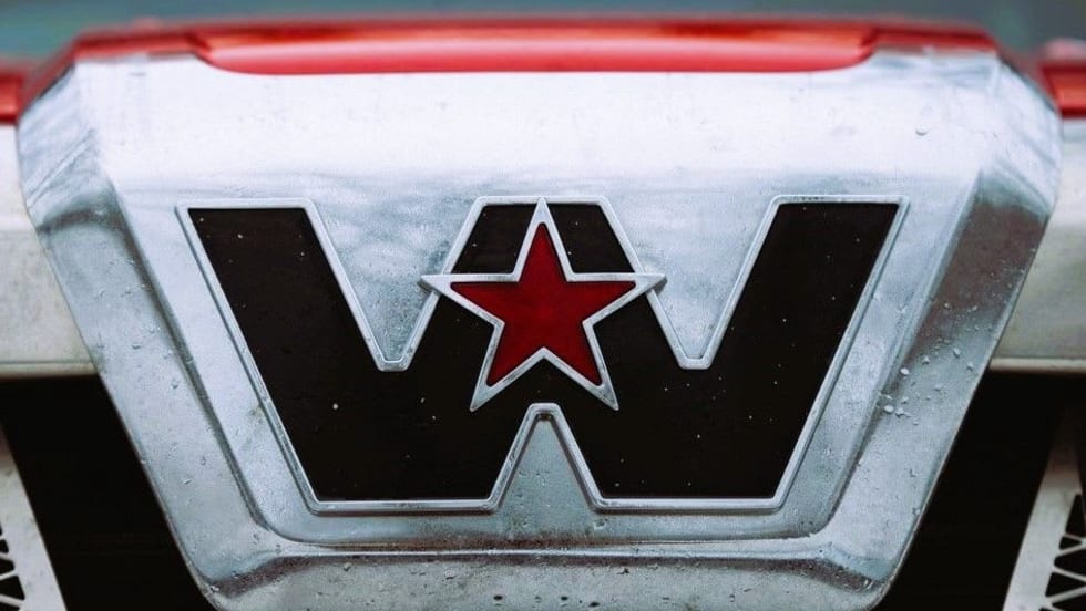 Close-up of Western Star truck logo with red star emblem on chrome grille, representing the brand’s identity in the trucking industry.