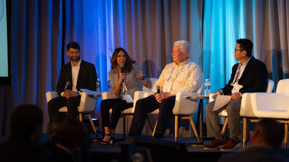 A panel of remarketing managers and experts on stage before a conference audience.