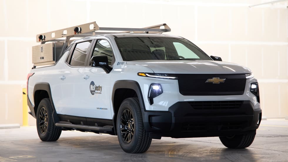 A full photo of a Silverado electric pickup rests in a stone garage with the McKinstry logo on its left side.
