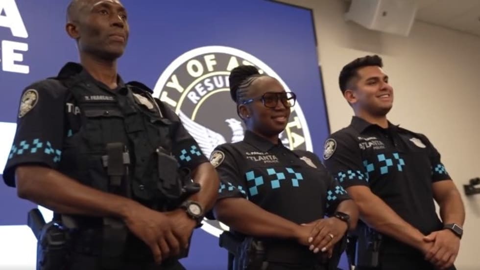 Three Atlanta police officers standing together at official press conference