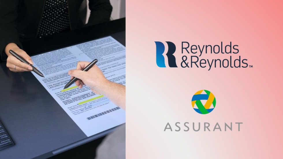 A customer signs documents on a digital e-contracting tablet using a stylus while a dealership employee points to the screen, alongside the Reynolds and Reynolds and Assurant logos.