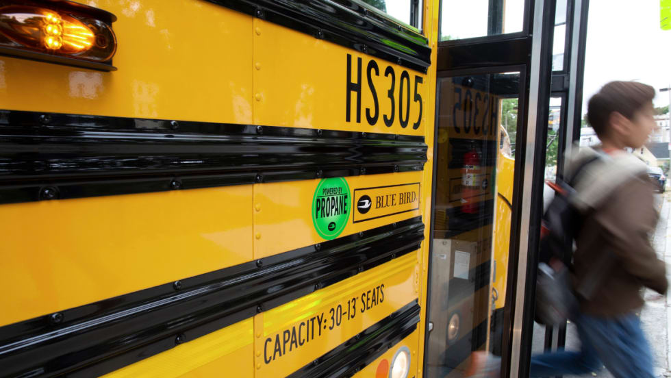 A student disembarks a propane school bus.