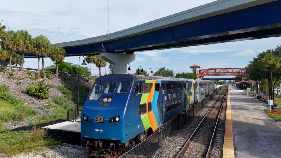 A light blue Tri-Rail at a station.