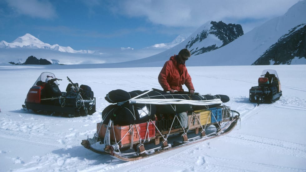 Explorer in Arctic packs sled. 