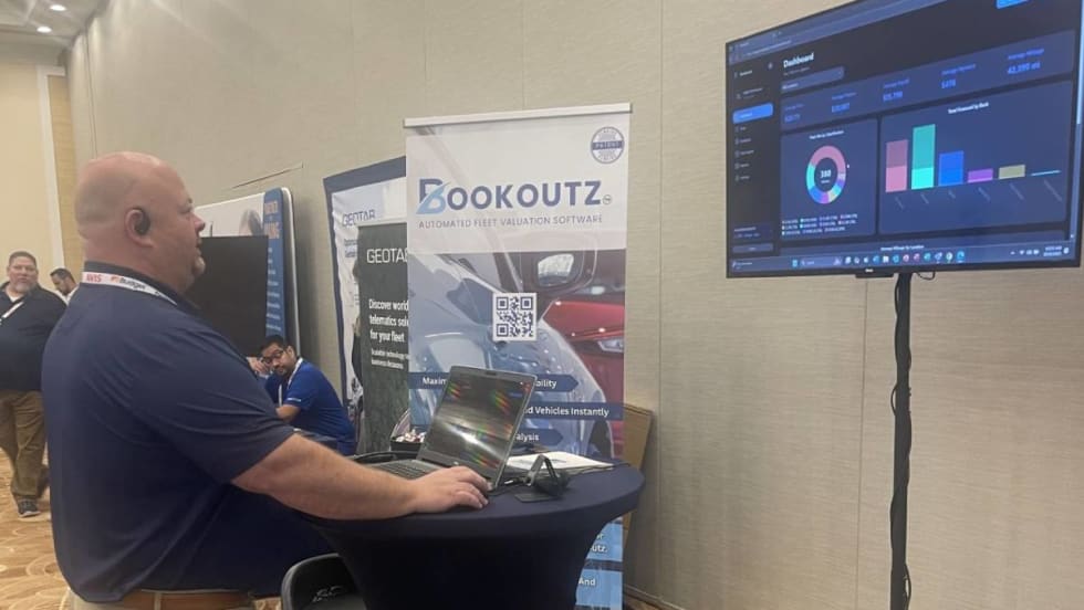 Bookoutz CEO demonstrating program on a laptop computer at a trade show.