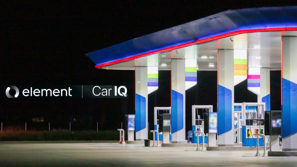 A gas station late at night sits on the right side of a dark photo.