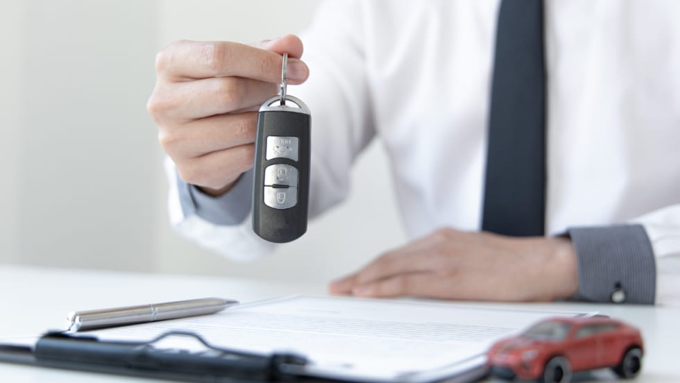 man holding up car keys