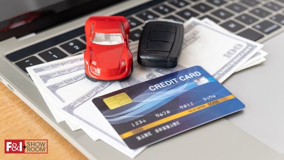 credit card, cash, toy car, car keys on top of laptop