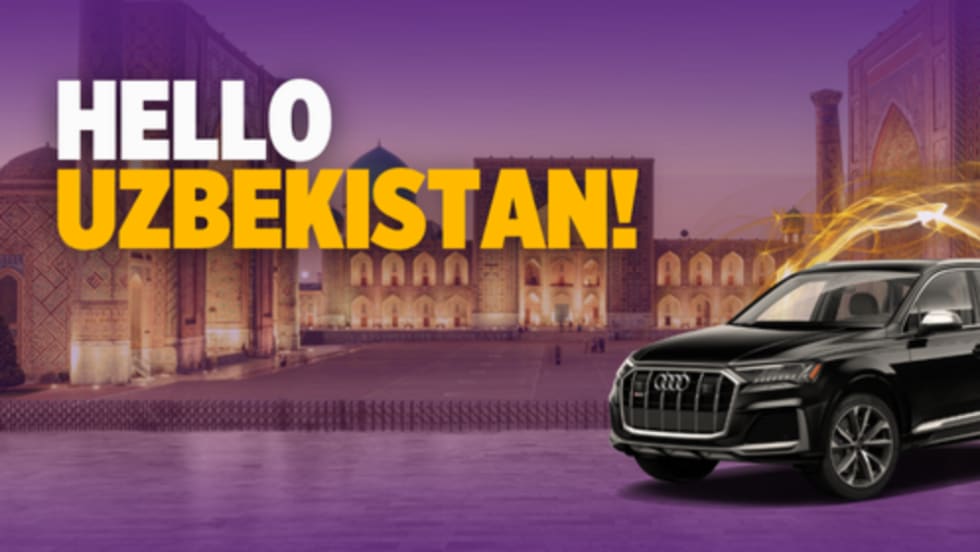 A black Audi SUV superimposed on a historic scene from downtown Tashkent, Uzbekistan.