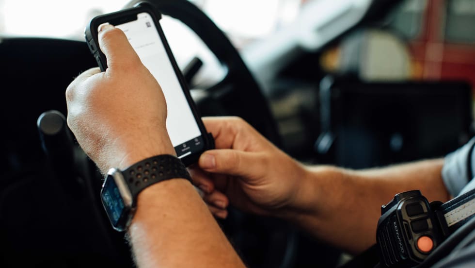 A man holding a phone in a truck. 