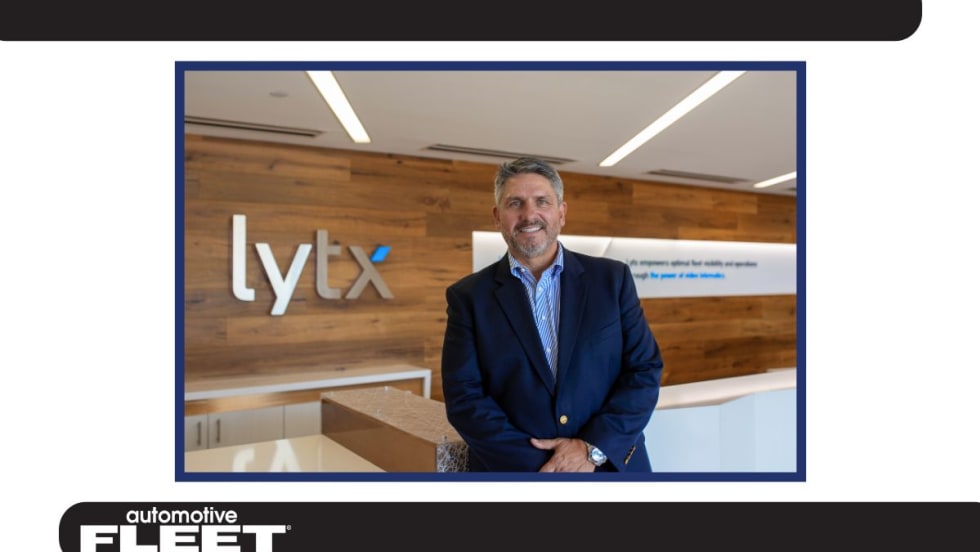 Chris Cabrera, newly appointed CEO of Lytx, stands in the company’s lobby, smiling in front of the Lytx logo.