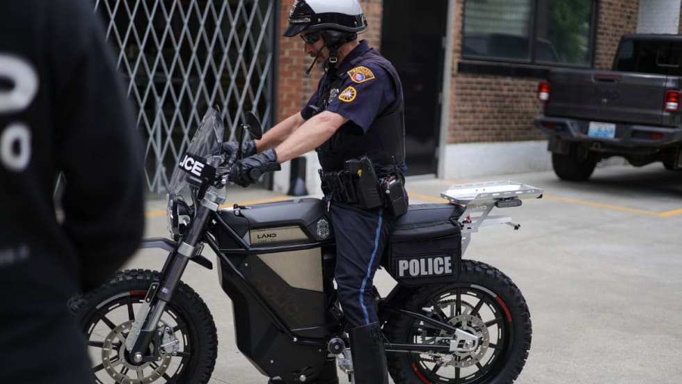 An officer sits on a silver and black e-bike called The District.
