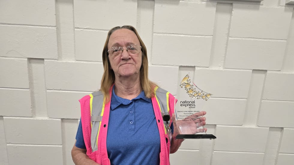 a woman holds an award