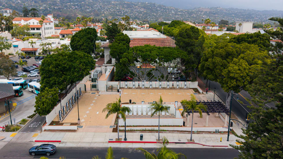 Overview of fast-charging depot in downtown Santa Barbara with panoramic view of coastal mountains and ocean in the background.