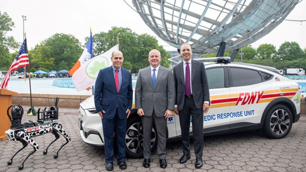 DCAS Deputy Commissioner Keith Kerman, FDNY Commissioner Robert S. Tucker, and DCAS Commissioner Louis A. Molina are standing in front of a new EV emergency medic response unit.