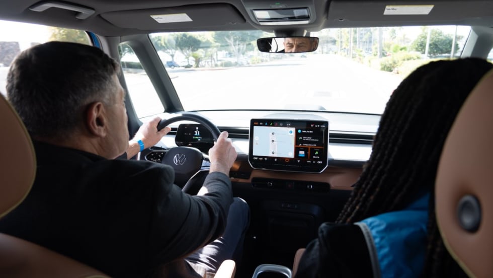 Interior shot of two people test driving a Volkswagen car.